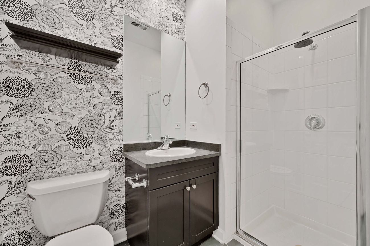 Damen Ave Condo — second bathroom with patterned wallpaper and glass shower