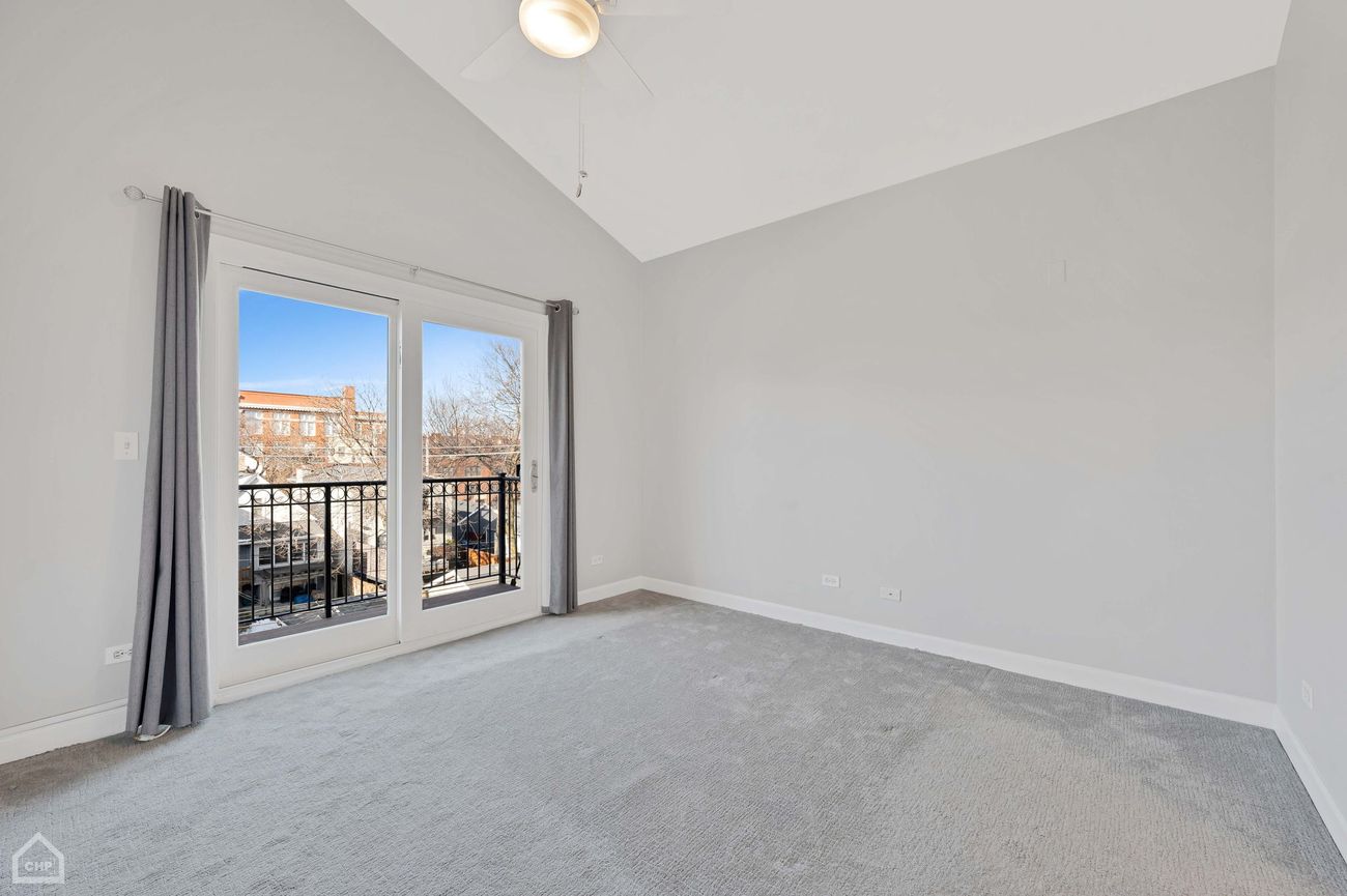 Damen Ave Condo — primary bedroom with vaulted ceiling and balcony access