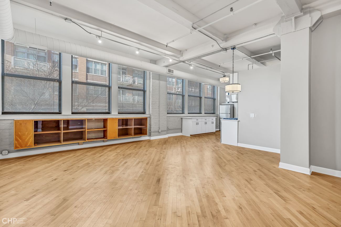 Sangamon Loft 1 — open living and kitchen area with exposed brick pillar