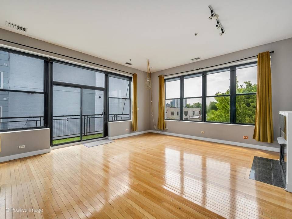The South Leavitt — living room with floor-to-ceiling windows and balcony access
