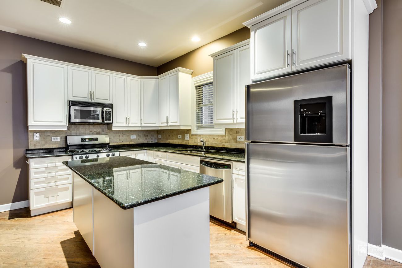 West Lakeview Duplex — kitchen with granite island and stainless appliances